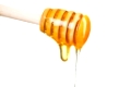 honey is dripping from the spoon, cut out from white