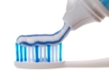 Zahnpasta wird aus einer Zahnpastatube auf eine Zahnbürste aufgetragen