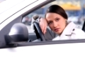 beautiful sensual woman put her head on steering wheel and looking back at camera