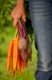 Eine Frau hält frisch geerntete Karotten und rote Rüben in ihrer Hand