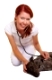 Glückliche Tierärztin untersucht einen liegenden Hund mit Stethoskop