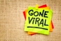 Gone viral - handwriting on a sticky note against burlap canvas