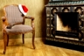 Old Antiques Armchair With Santa's Hat Near The Fireplace