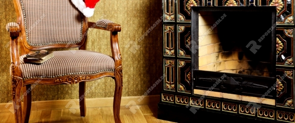 Old Antiques Armchair With Santa's Hat Near The Fireplace