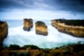 Loch Ard Gorge at Great Ocean Road. This long-exposure captures the movement of waves and clouds around the beautiful landmark of orange rocks