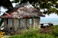 Hut with flags under tree on the beach in Savaii island, Samoa