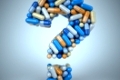 Pills or capsules as a question mark on blue background 3d