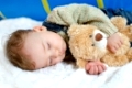 schlafender Junge mit Teddybär im Armsleeping boy with teddy bear in her arms