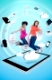 Two cute women jumping on a tablet pc against a digital blue background