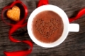 Mug of hot chocolate or cocoa with cookies decorated by red ribbon