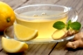 Heißer Tee mit Zitrone und Ingwer auf rustikalem Holz