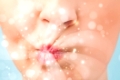 Pretty woman lips blowing abstract white lights - close up