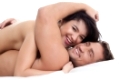 Happy naked lovers embracing lying in bed, close-up
