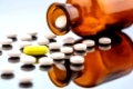 Viele Tabletten mit einem Glasbeghäter. Symbolfoto für Sucht und Kosten in der Medizin und bei Medikamenten.