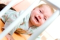 kleinkind im gemütlichen gitterbett beim weinen
