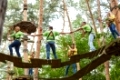 Gruppe beim Klettern im Hochseilgarten als Teambuilding Aktivität im Sommer
