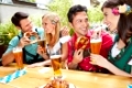 Männer und Frauen flirten beim Oktoberfest mit Bier und Brezel