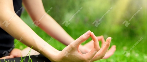Young woman in the lotus position close up. Yoga meditation at outdoor. Copyspace
