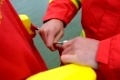 Rettungsschwimmer demonstriert das Anlegen eines Rettungsgerätes