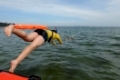 Rettungsschwimmer springt vom Boot ins wasser um Badende zu retten