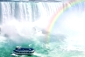 Spectacular rainbow near tourist boat at Niagara Falls