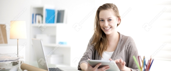 a beautiful young woman on the workplace using a digital tablet