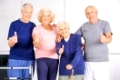 Zufriedene Gruppe Senioren im Pflegeheim hält die Daumen hoch