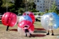Boys are playing bubble football game in the park.