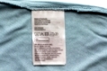 clothes, laundry and housekeeping concept - label with users manual of clothing item