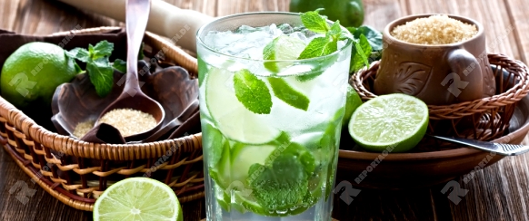 Mojito cocktail delicious summer drink with lime, mint and ice on rustic wooden background 