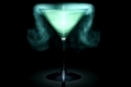 A blue smoking cocktail glass in front of a black background