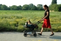 Anja Adler mit Ihrer amputierten Hündin Nora. Nora wird mit einem Kinderwagen vom Sperrmüll spazieren gefahren.